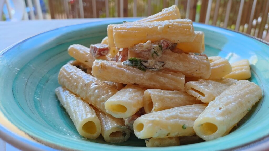 Servi nei piatti la pasta gustosa con ricotta a e pancetta