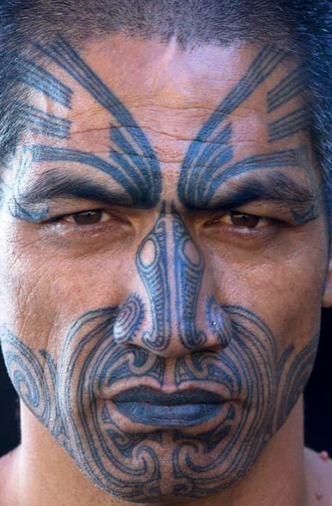 Uomo Maori con tatuaggio tradizionale Ta Moko sul viso